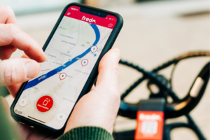Fredo app in hand in front of bicycle